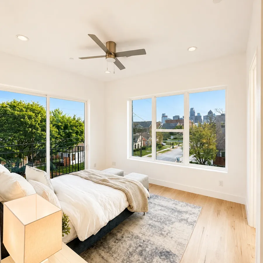 Bedroom with large windows and a skyline view